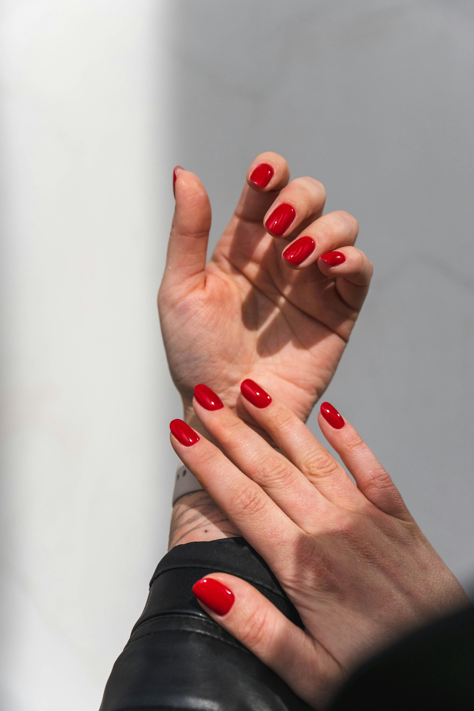 Glossy burgundy red manicure on a dark background — L.A. Nails, Traverse City MI